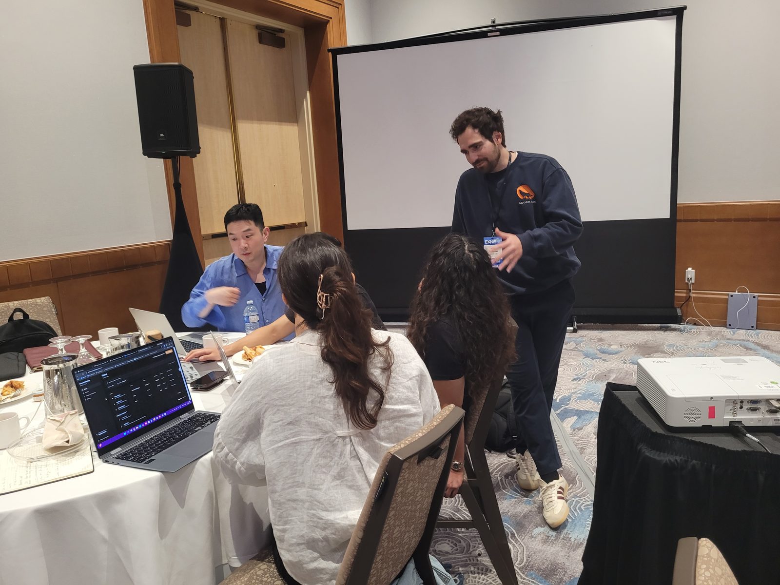 Moonlite Labs founder Adam Fainman briefing a team on the pre-competition workshop as they work on laptops at the EXNW hack-a-thon